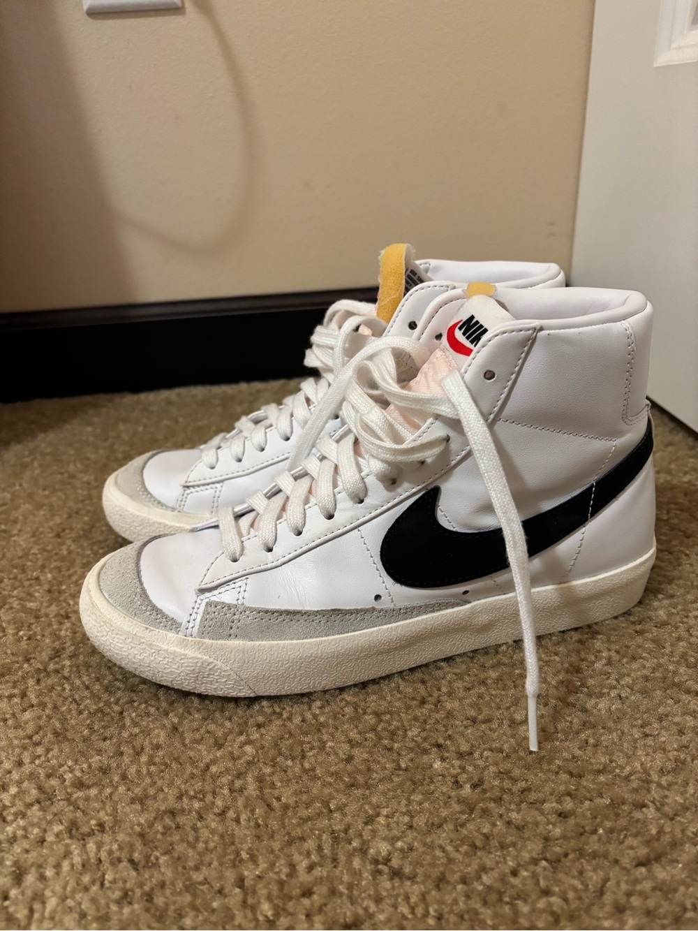 Nike White High-Top Sneakers with Black Swoosh and Yellow Tongue